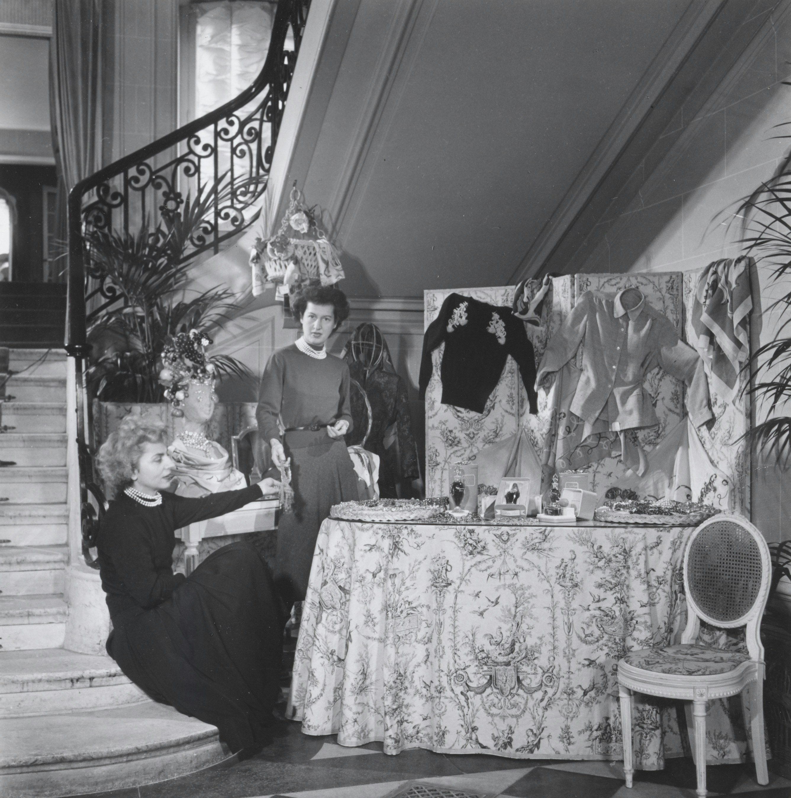 Carmen Colle est assise en bas des escaliers à l'entrée de la maison Dior au 30, Avenue Montaigne, elle se trouve près des accessoires et parfums vendus dans la boutique Colifichets.